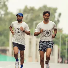 Two of our runners in sync during a training run, wearing our team gear with pride. We represent a community of dedicated athletes.