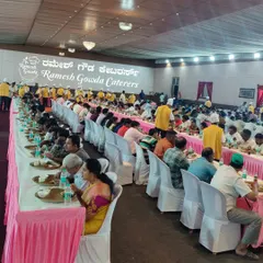 A long shot of a dining hall during a busy lunch service. You can see our staff in yellow uniforms ensuring smooth service for all the guests seated in long rows.