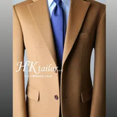 A classic camel colored blazer on a mannequin, showcasing the sharp cut and notched lapels. This is a versatile piece that can be paired with formal trousers or jeans.