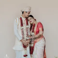 A quiet, tender moment between the bride and groom in their traditional wedding attire. The bride rests her head on his shoulder, a simple gesture full of emotion.