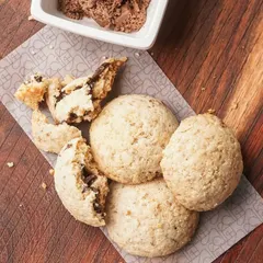 A close-up of my gluten-free Lava Cookies, one broken open to reveal the gooey chocolate inside. They are made with oats, dark chocolate, and puffed quinoa for a treat that's both delicious and nourishing.