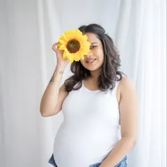 A little bit of fun with a sunflower prop. This playful solo portrait is simple, sweet, and shows that maternity photos can be lighthearted and cheerful.