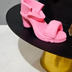 A tiny, edible pink high-heeled shoe, handcrafted as part of a makeup and fashion-themed cake. Creating miniature, realistic items like this is one of my specialties.
