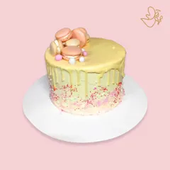 A delightful macaron drip cake for Yushi's birthday. This cake is topped with a pile of pretty macarons and finished with a white chocolate drip and colorful sprinkles.