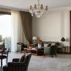 For the expansive central lounge at the new Maddock office, I chose to create several intimate seating areas instead of one large one. This approach encourages smaller, more personal conversations, turning a large hall into a series of warm, inviting corners for creative collaboration, all anchored by timeless wall paneling and a classic crystal chandelier.