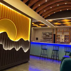 A closer look at our newly designed bar area with cool blue ambient lighting. It's a great spot to pull up a stool and enjoy a drink, highlighting the modern and cozy feel of our space.