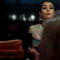 A candid look in the mirror during a break backstage. These are the moments of focus and preparation that the audience never sees, ensuring every detail is perfect before stepping into the spotlight.