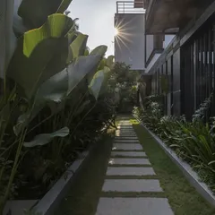 A landscaped stone pathway at the 'Mango Tree Yard' residence. We carefully designed the outdoor spaces to create a journey through the property, connecting the built form with the surrounding greenery and sunlight.