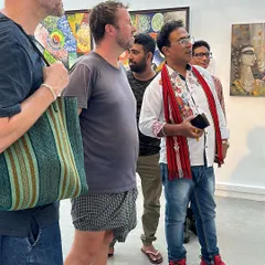 Engaging with international visitors at my art exhibition, explaining the stories behind my paintings.