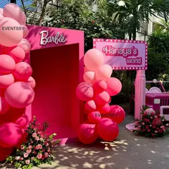 The entrance to 'Hanaya's World', a Barbie-themed party with a pink doorway, balloon arch, and a pink jeep.