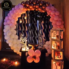 This is one of our popular romantic home birthday setups. It features a circular balloon arch, a "BABY" block display, and soft candlelight to create a cozy and intimate atmosphere perfect for a surprise celebration.
