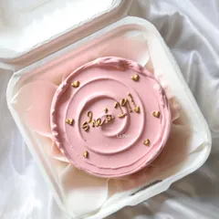 A pretty pink bento cake with "She's 1/1" written in gold, celebrating someone who is truly one of a kind.
