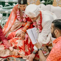 The couple participates in a fire ritual during their wedding ceremony, a serene moment of prayer and togetherness at the Leela Palace Bangalore.