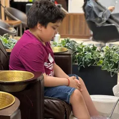 A young client patiently enjoying a foot soak. I ensure the experience is comfortable and fun for kids, making it a positive salon visit for the whole family.