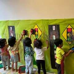 Teamwork makes the dream work! In our transport-themed week, these little artists worked together on a giant wall mural, painting traffic lights and roads. It's a great way for them to learn collaboration while having creative fun.