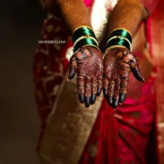 A professional shot capturing the deep, dark stain on a bride's palms during her wedding ceremony.