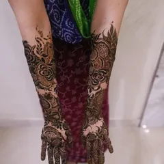This fusion design combines the boldness of Arabic mehendi with the intricacy of Indian patterns. The floral vines on the arms create a beautiful flow, while the hands remain detailed and full.