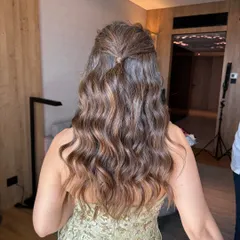 A simple yet elegant half-updo with soft, flowing waves. This hairstyle is perfect for a Mehendi or Engagement, offering a chic and effortless look.