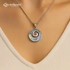 This unique Abalone Spiral pendant features iridescent shell inlay within a carved silver frame. The spiral symbolizes growth and evolution, making this a beautiful and meaningful accessory.