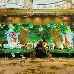 This full stage view highlights the combination of green foliage and gold sequin backdrops for a touch of glam in a jungle theme.