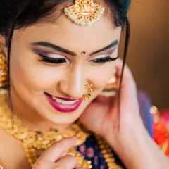 A tight close-up that focuses on the model's joyful expression and the fine details of her makeup and jewelry. This type of shot is essential for highlighting specific pieces like the nose ring and maang tikka for accessory brands.