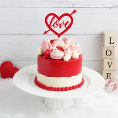 A stunning red and white Valentine's cake topped with macarons and a "Love" topper. It's a beautiful and delicious way to express your feelings.