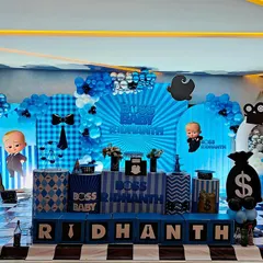 We love bringing fun themes to life, like this "Boss Baby" setup for Ridhanth's celebration. The decor includes custom character cutouts, themed props like money bags, and a coordinated blue, black, and white balloon and backdrop design.