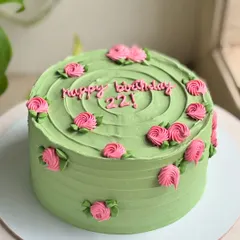 22 and blooming. This cake pairs a soft sage green buttercream with delicate pink rosettes for a timeless and fresh birthday design.