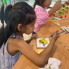 A young artist carefully painting a tile in our dedicated art room. We provide all the supplies for a fun and mess-free creative experience.