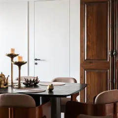 A detail shot showing the contrast between the antique wooden door and the clean, modern lines of the dining area. This juxtaposition of old and new is a signature element of our design philosophy.