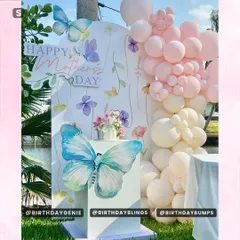 A beautiful Mother's Day setup with a butterfly and floral theme, featuring a soft pink and white balloon garland in an outdoor setting.