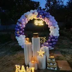 I can transform any outdoor space, even at night. This 'Bride to be' garden party setup uses a lighted balloon ring, a glowing neon sign, and illuminated marquee letters to create a dreamy and enchanting ambiance perfect for an evening celebration.