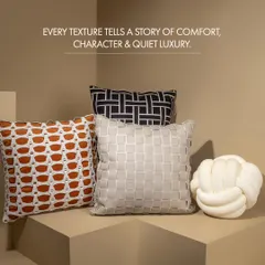A home's comfort is in the details. This collection of designer cushions, featuring a knotted pillow and textured basket-weave covers, adds character and a touch of quiet luxury to any living space.