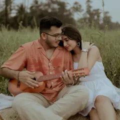 A perfect picnic moment. He plays the guitar for her in a beautiful green field, a simple and incredibly romantic scene for a pre-wedding shoot.