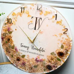 A full view of the 16-inch 'story of manifestation' clock. The combination of preserved flowers, pearls, and a custom monogram makes it a truly personal and functional piece of art.