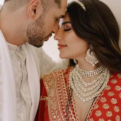 An intimate close-up of the couple. This shot highlights the bride's magnificent layered Tyaani Jewellery necklace and statement earrings, which were the centerpiece of her wedding look.