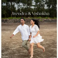 An energetic and joyful shot from a beach pre-wedding session. This image captures the fun and carefree spirit of a couple, running barefoot on the sand with the shoreline and trees creating a natural, beautiful frame.