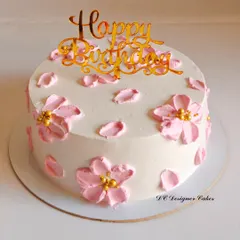 A delicate birthday cake decorated with pink cherry blossoms. The design is inspired by Korean-style cakes, known for their clean and artistic floral work.