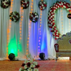 This stage features a large heart-shaped floral arch made of red and white flowers. Paired with hanging floral bouquets and string lights, it creates a beautiful and romantic focal point for an engagement or reception.