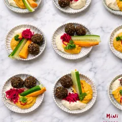 An overhead view of my Mini Mezze Platters, designed for elegant and easy party catering. Each individual plate offers a perfect portion of hummus, falafel, and fresh veggie sticks for your guests.