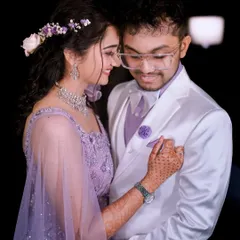 An intimate moment between the couple, their matching lavender outfits perfectly complementing the reception's romantic theme.