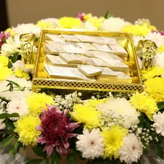 We assembled this vibrant platter for a nikah ceremony, surrounding a box of traditional Indian sweets (Kaju Katli) with a ring of fresh yellow, white, and purple chrysanthemums.