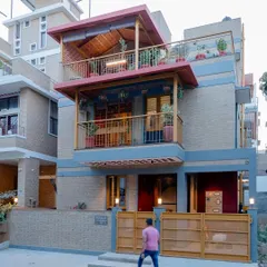 The facade of Audumbara, where earthy CSEB walls are complemented by vibrant yellow gates and railings. This view shows how I balance natural materials with carefully chosen pops of color.