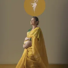 A serene solo portrait of the mother to be in her yellow saree, eyes closed in peaceful contemplation. The 'Maa' symbol above her head beautifully completes this tribute to motherhood.