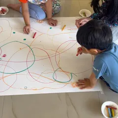 Another angle of our collaborative drawing session. This activity helps develop social skills as children learn to share tools and space, all while contributing to a single, large-scale piece of art.