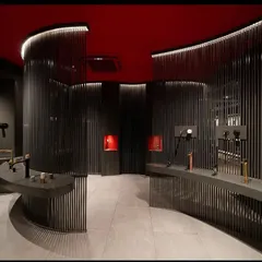 In the Fima showroom, the lighting is designed to be dramatic and bold. I used concealed linear lights to trace the curves of the slatted walls, creating a captivating play of light and shadow that draws customers in. The vibrant red ceiling is intentionally left dark to enhance the moody, focused atmosphere.