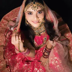 An artistic top-down shot of a bride in her full lehenga and jewelry. This showcases the complete look, from the intricate *matha patti* to the flow of the dupatta.
