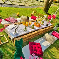 A closer look at the rustic-chic picnic table, showing the mix of fresh flowers, cushions, and decorative items that create a relaxed and beautiful atmosphere.