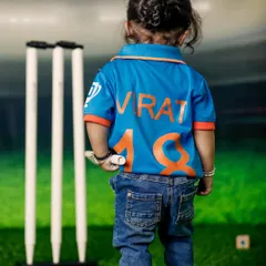 A tribute to a cricket legend. This toddler is proudly wearing a "Virat 18" jersey, ready to step onto the pitch. It's a fun way to celebrate a family's passion for the sport.
