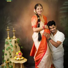 A playful and loving pose where the dad-to-be rests his head on the baby bump. This captures the couple's joy and connection within the beautiful context of their traditional attire.